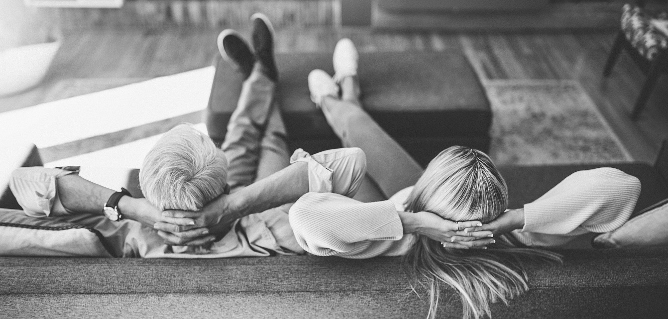 Couple sitting on couch relaxing.