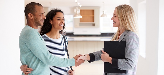 Realtor shaking hands with a couple.